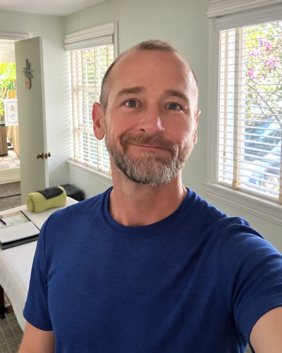 Van in a blue T-shirt, with the treatment-room setting behind him