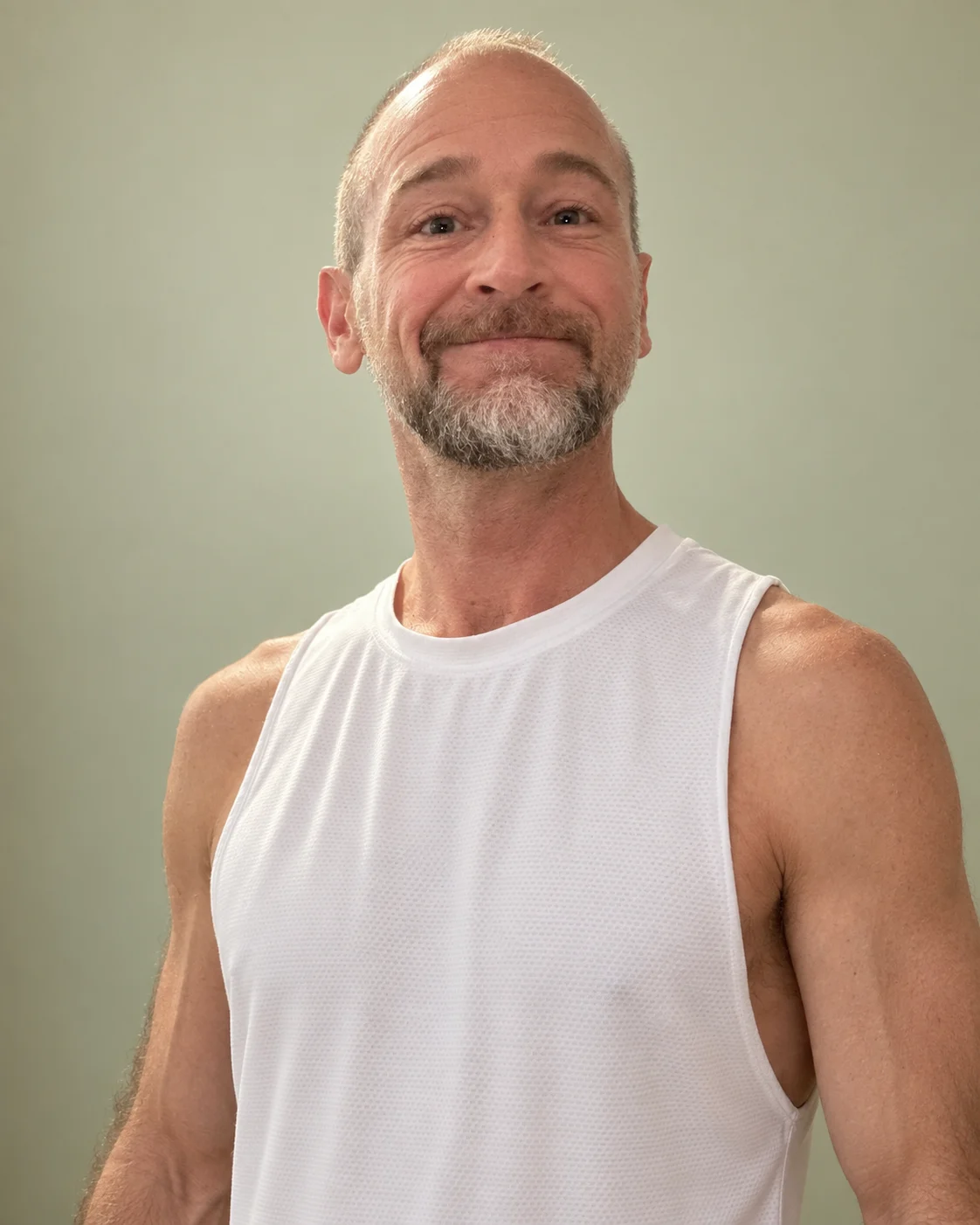 Van Pullum, massage therapist, smiling in a white sleeveless shirt